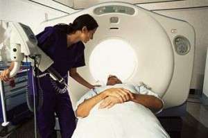 A radiation technician prepares a pancreatic cancer patient for a CT scan