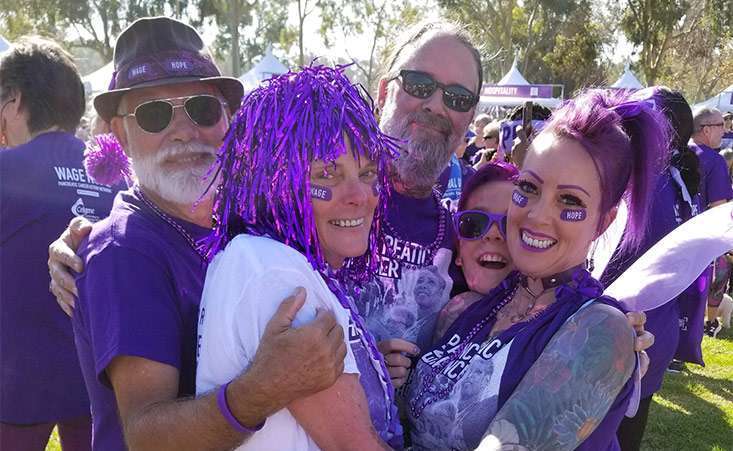 PurpleStride participants hug their teammate and pancreatic cancer survivor at the 5K walk.