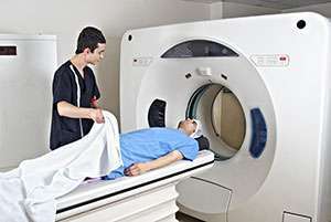 A radiation technician prepares a pancreatic cancer patient for a PET scan.