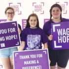 High schooler and her two friends holding signs of hope at the walk to end pancreatic cancer