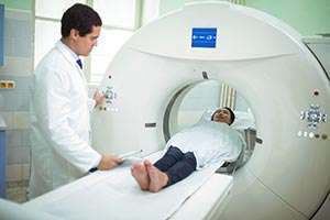 A radiation technician prepares a pancreatic cancer patient for her MRI scan