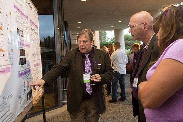 Pancreatic cancer researcher explains his scientific poster to PanCAN volunteers at conference
