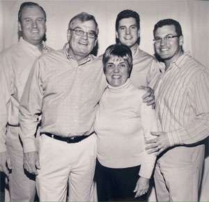 1960’s era black and white photo of Caucasian family: Mom, dad, three teenaged brothers.